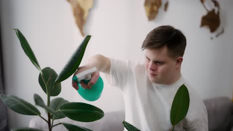 man with down syndrome spraying houseplants with care