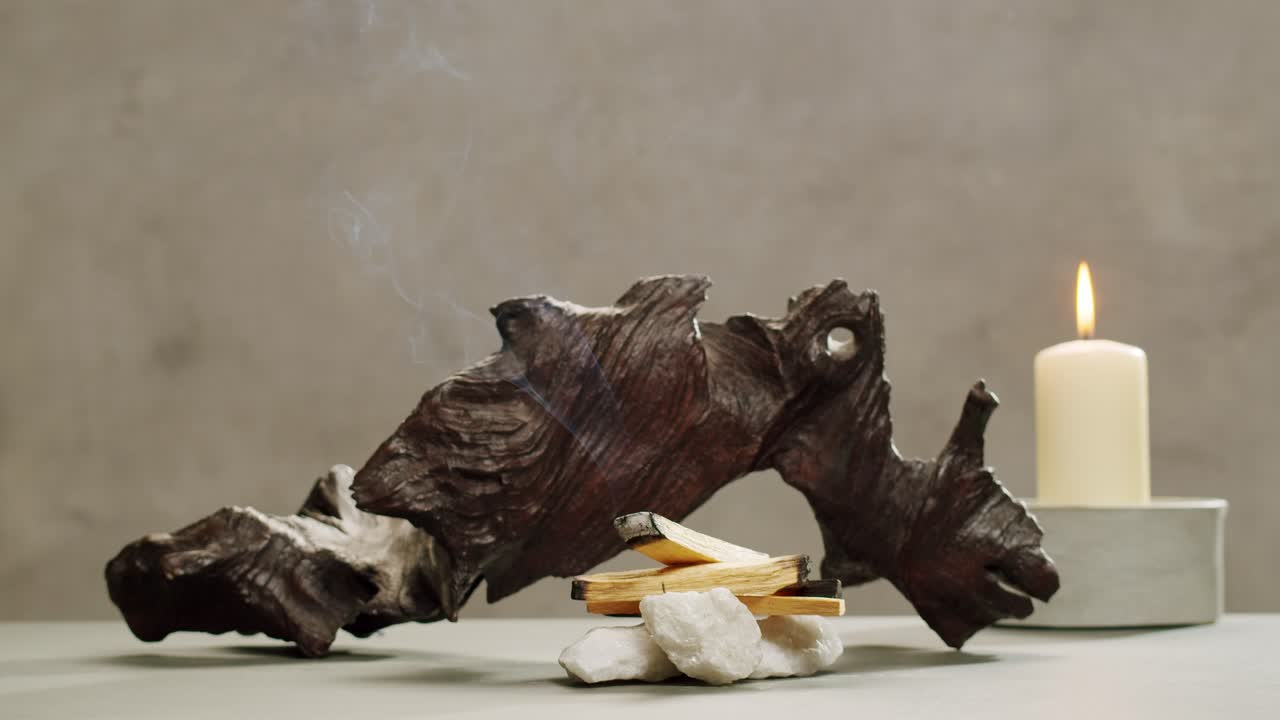 Person holding Palo Santo wood stick in hand, aromatic Palo Santo burning on black background, smoke spreading around, slow motion video clip, high quality 4k close up footage. High quality 4k footage