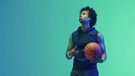 video of biracial male basketball player with ball on green background