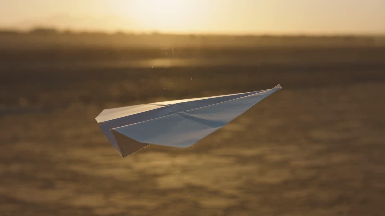 Paper Airplane Soaring Against a Warm Sunset Horizon