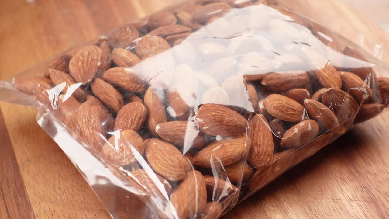 나무판 위에 플라스틱 봉투에 담긴 아몬드