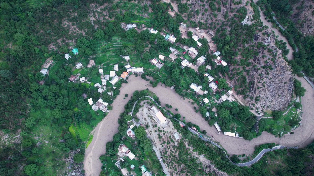 Vista dall'alto di acque alluvionali che circondano un villaggio di montagna dopo un nubifragio, Valle di Neelum, Kashmir.