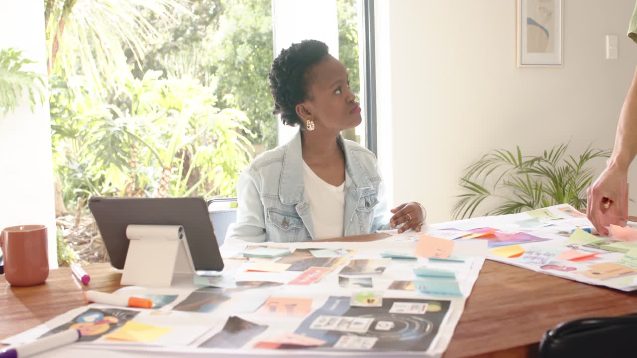 Diverse coworkers reviewing design mockups and brainstorming at workspace, copy space