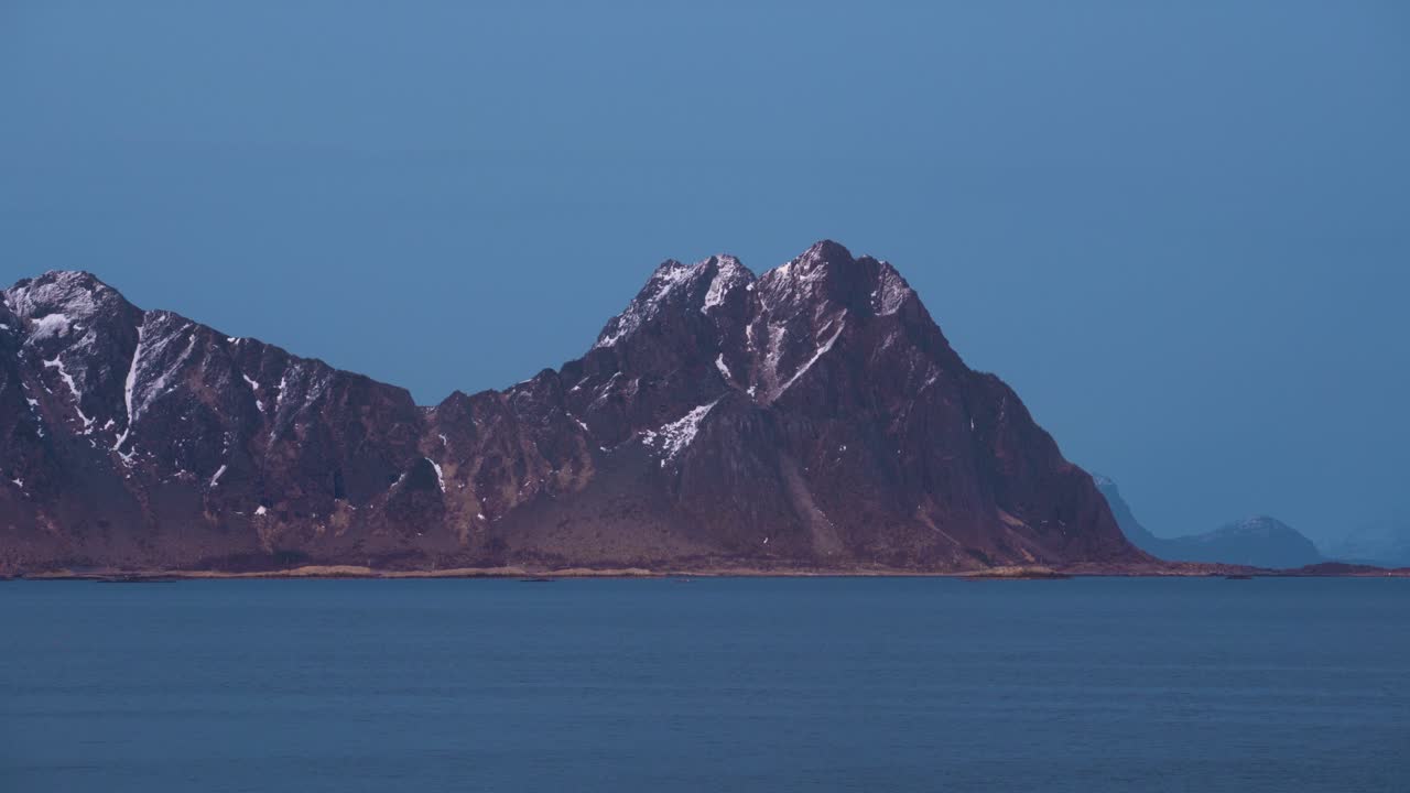 A clip of a mountain in the distance located in the sea