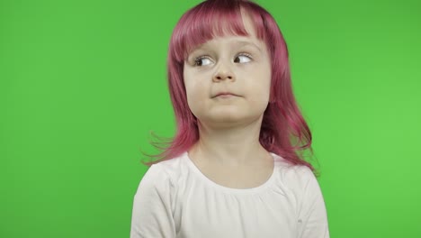 a young girl with pink hair looks up in a studio