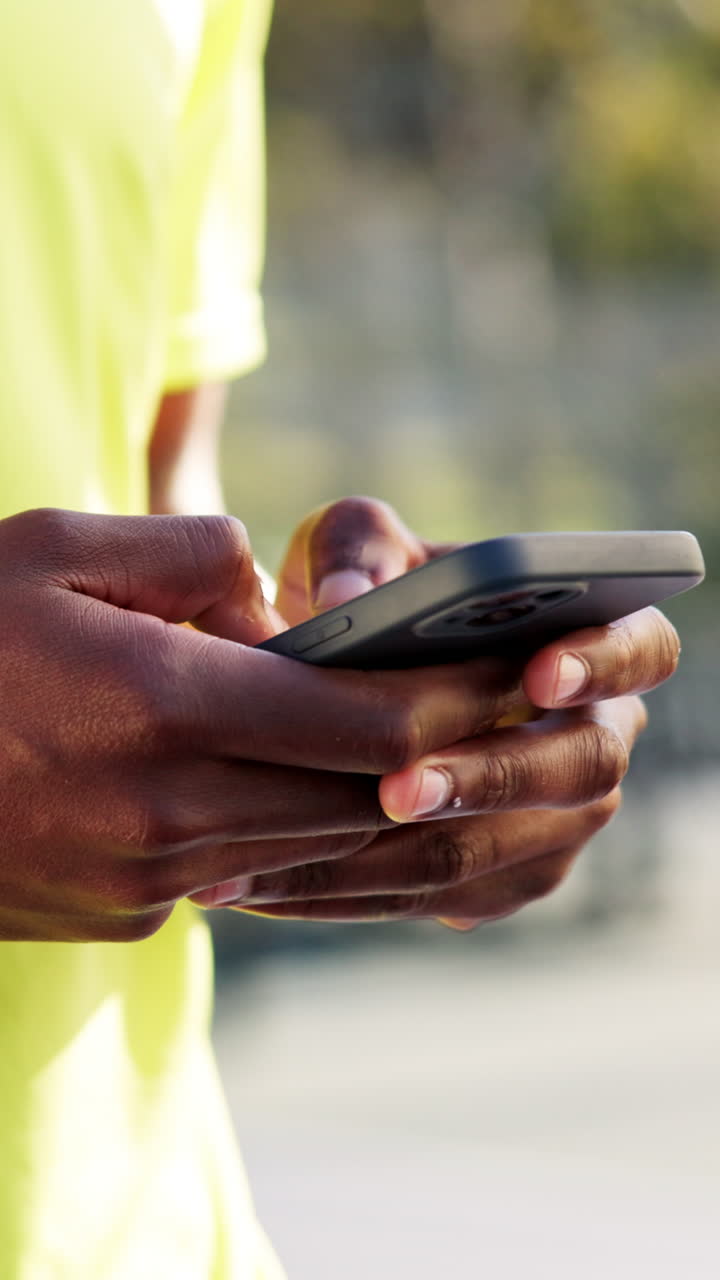 Close-Up of Hands Typing on a Smartphone Outdoors