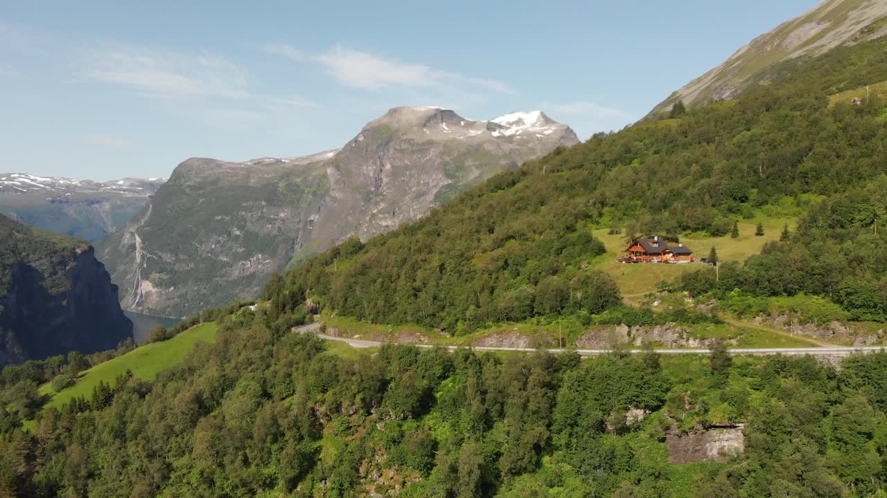 una carretera y una casa junto al geirangerfjord en noruega