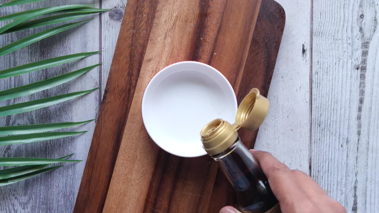 vertiendo salsa de soja en un cuenco