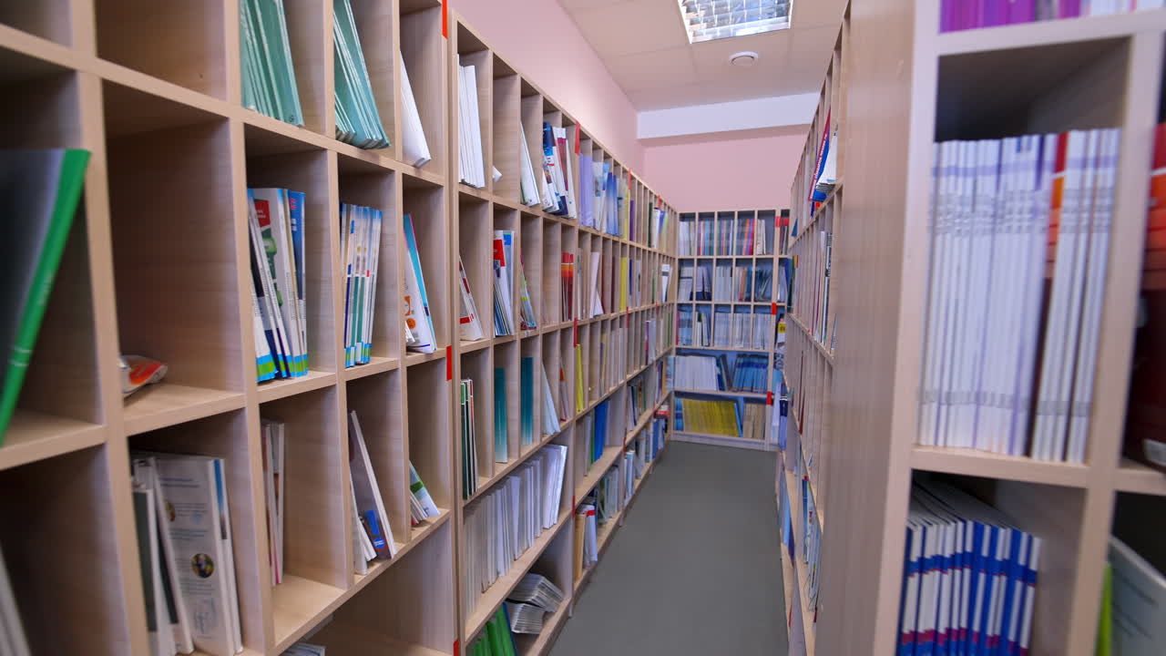 Modern bookstore. Educational literature stacked on shelves for students in the library. Wooden bookcases with many books indoors.