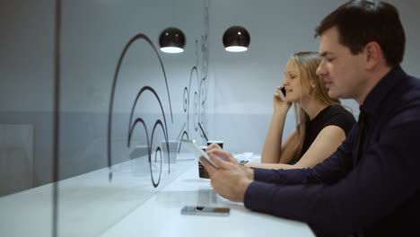 Friends-in-cafe-busy-with-phone-and-pad