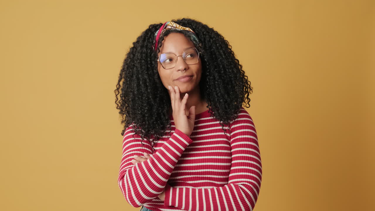 Thoughtful Young Woman with Curly Hair Smiling at Camera