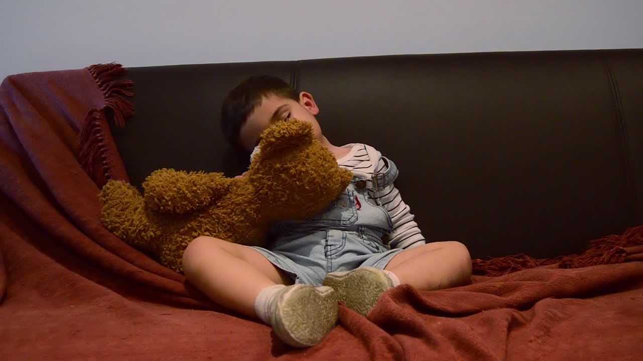 귀여운 피곤한 유아가 소파에서 잠이 들었습니다 - 재미있는 아기 얼굴 표정