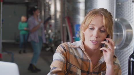 Female-Worker-On-Mobile-Phone-With-Laptop-Checking-Production-Inside-Winery