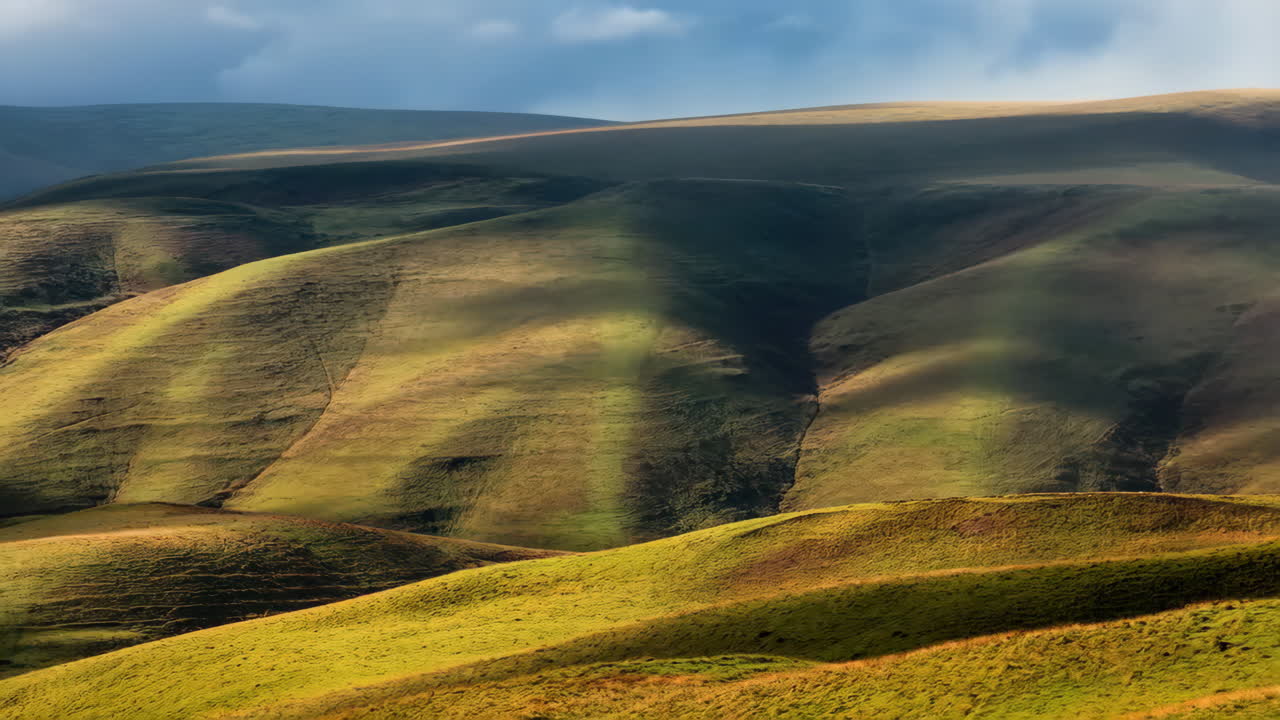 Rolling Green Hills Bathed in Sunlight and Shadows