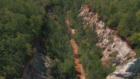 Atemberaubende-Drohnenaufnahmen-Von-Menschen,-Die-Am-Fuß-Einer-Riesigen-Schlucht-Wandern