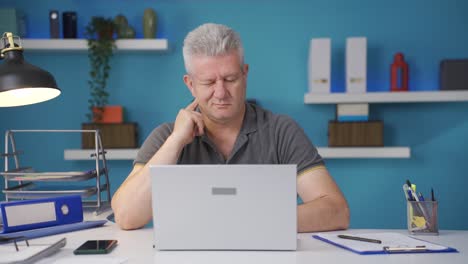 Home-office-worker-man-scratches-his-ears-looking-at-camera.