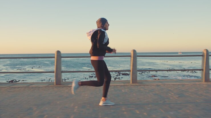 Exercise, fitness and woman running by ocean
