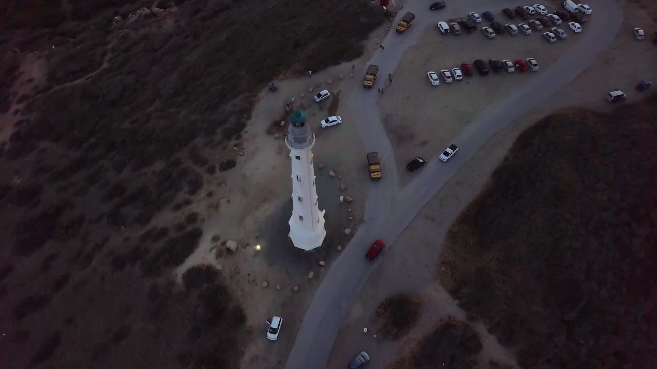 camiones amarillos conduciendo alrededor del faro de california en aruba