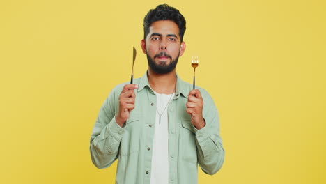 hombre hambriento esperando para servir la cena platos de comida con inquietud sosteniendo cubiertos cuchillo horquilla