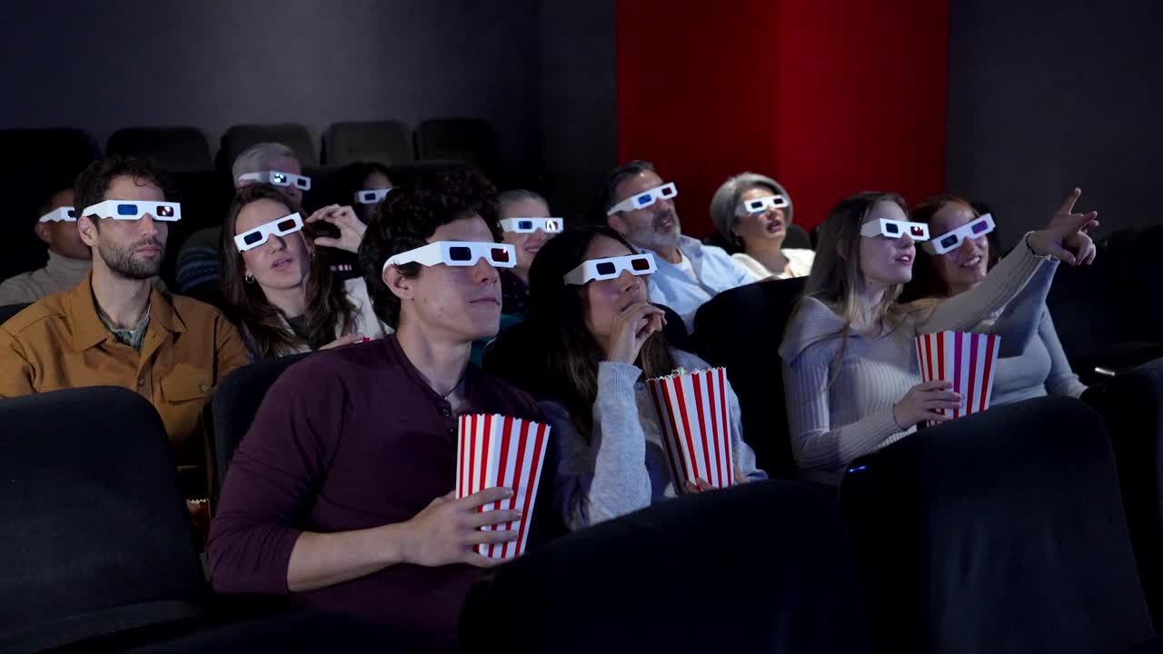 People enjoying a 3D movie in a theater with popcorn