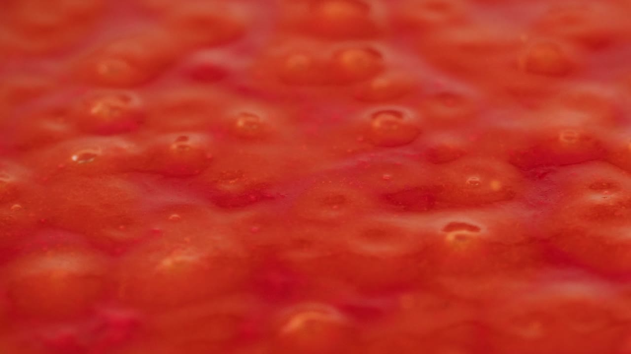 Boiling tomato sauce on a frying pan close-up. Cooking tomato sauce or soup. Traditional Italian Mexican Asian dish. High quality studio shot for cafe, restaurant close up. Marinara sauce for Italian pasta