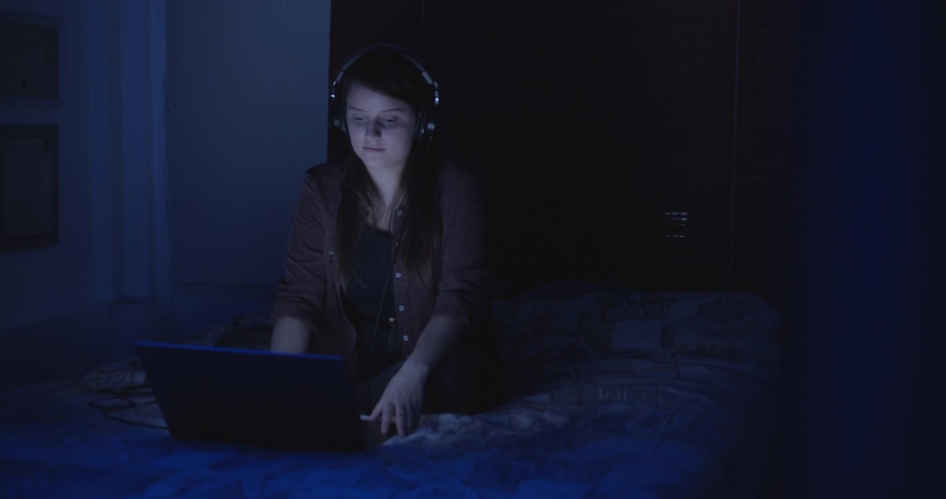 Woman with headphones in the bedroom
