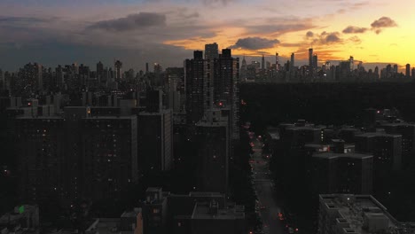 Drone-lowering-shot-of-Harlem-NYC-looking-down-5th-Avenue-at-sunset-in-4K