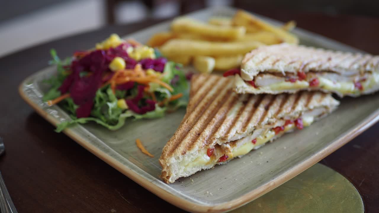 sándwich de pollo a la parrilla con papas fritas y ensalada