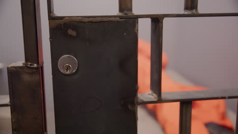 inmate in a prison cell sleeping on uncomfortable bed