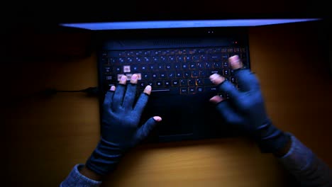 Hacker-hand-stealing-data-from-laptop-top-down