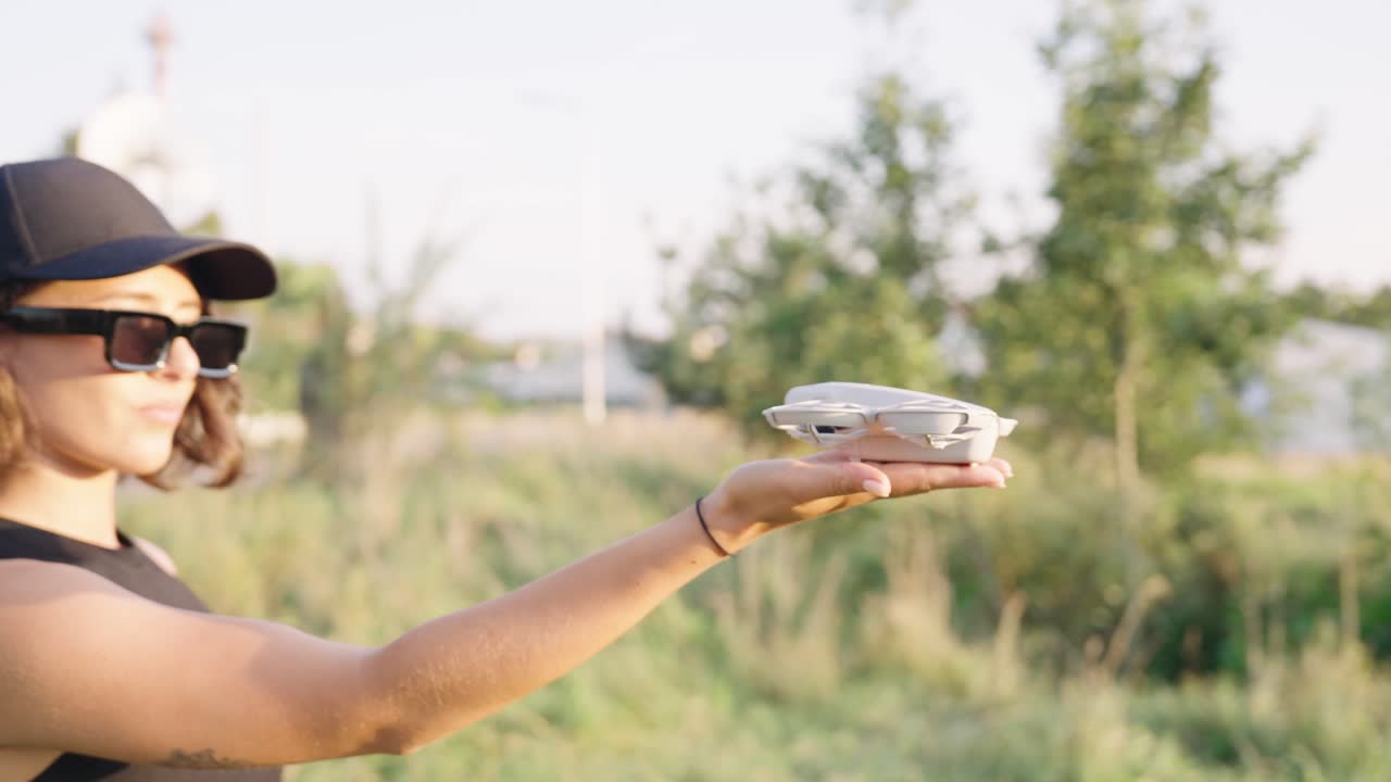 Compact drone take off from female palm in bright outdoor environment, Czechia