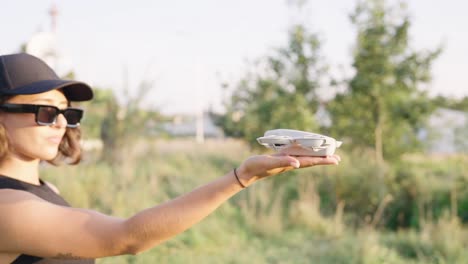compact drone take off from female palm in bright outdoor environment, czechia