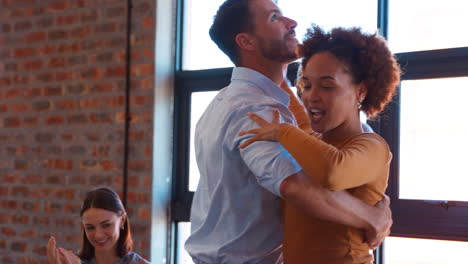 equipo de negocios celebrando en una reunión en una oficina multicultural con colegas bailando y divirtiéndose