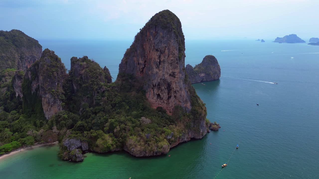 Rock climber on a difficult climb on Rai Leh beach cliff in Thailand. Amazing aerial view flight panorama overview drone