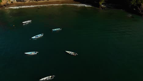 drone view of fishing boats anchored in a cliff side fishing village