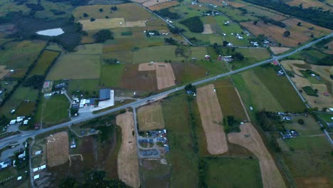 aerial drone rural landscape in green agricultural chilean outskirts, avenue through panoramic fields, south america