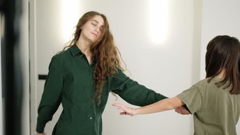 young mother and daughter dancing relaxfuly at home, having fun together