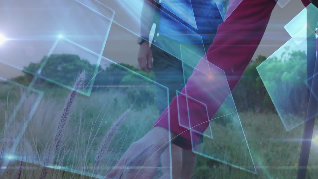 Mature hiking couple trekking meadow, demonstrating outdoor tech with blue shapes and light flares
