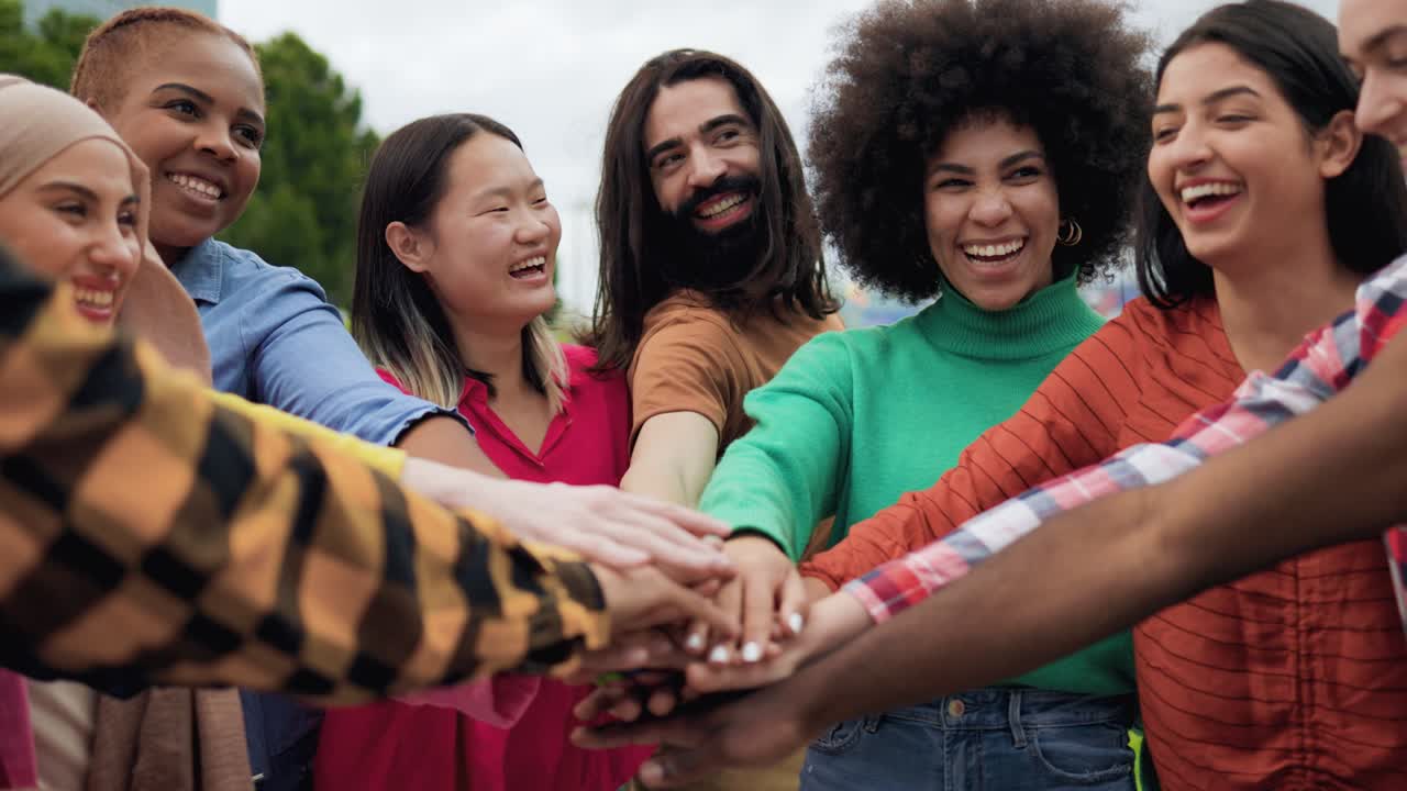 joven grupo multiétnico de personas que se juntan las manos al aire libre - trabajo en equipo concepto de diversidad y unidad