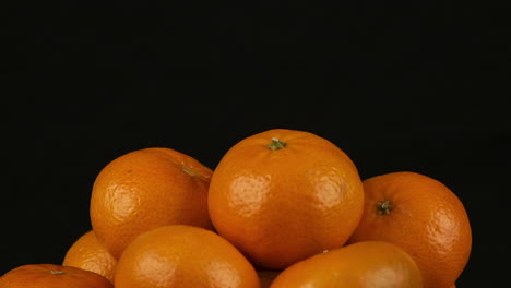 isolated food: pile or oranges revolves against black background