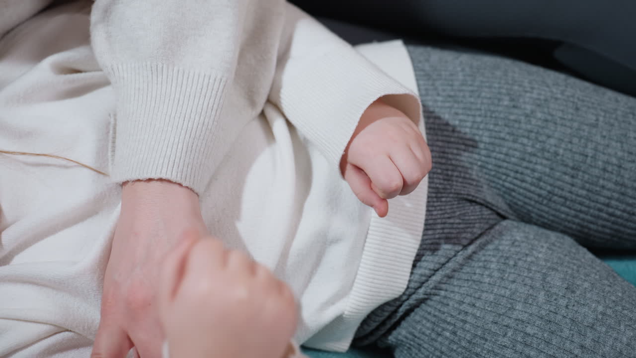 Closeup of mother hand resting gently on child chest while child hand lies nearby, showing tenderness, comfort, warmth, nurturing care, protective bond, affection, love, safety, family connection