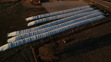 aerial shot of long plastic cylindres covering forage