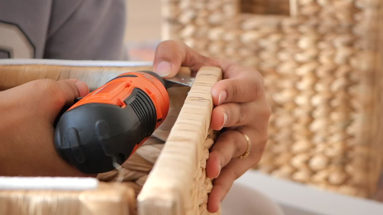 Close-up of hands using a tool on a wooden frame