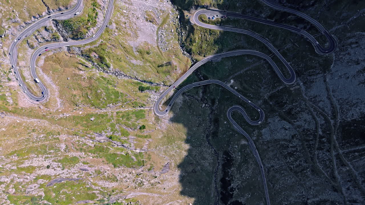 Scenic aerial view of winding Transfagarasan road in sunlight and shadow