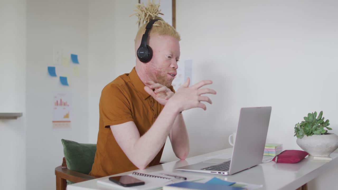 Albino african american man with dreadlocks making video call on the laptop