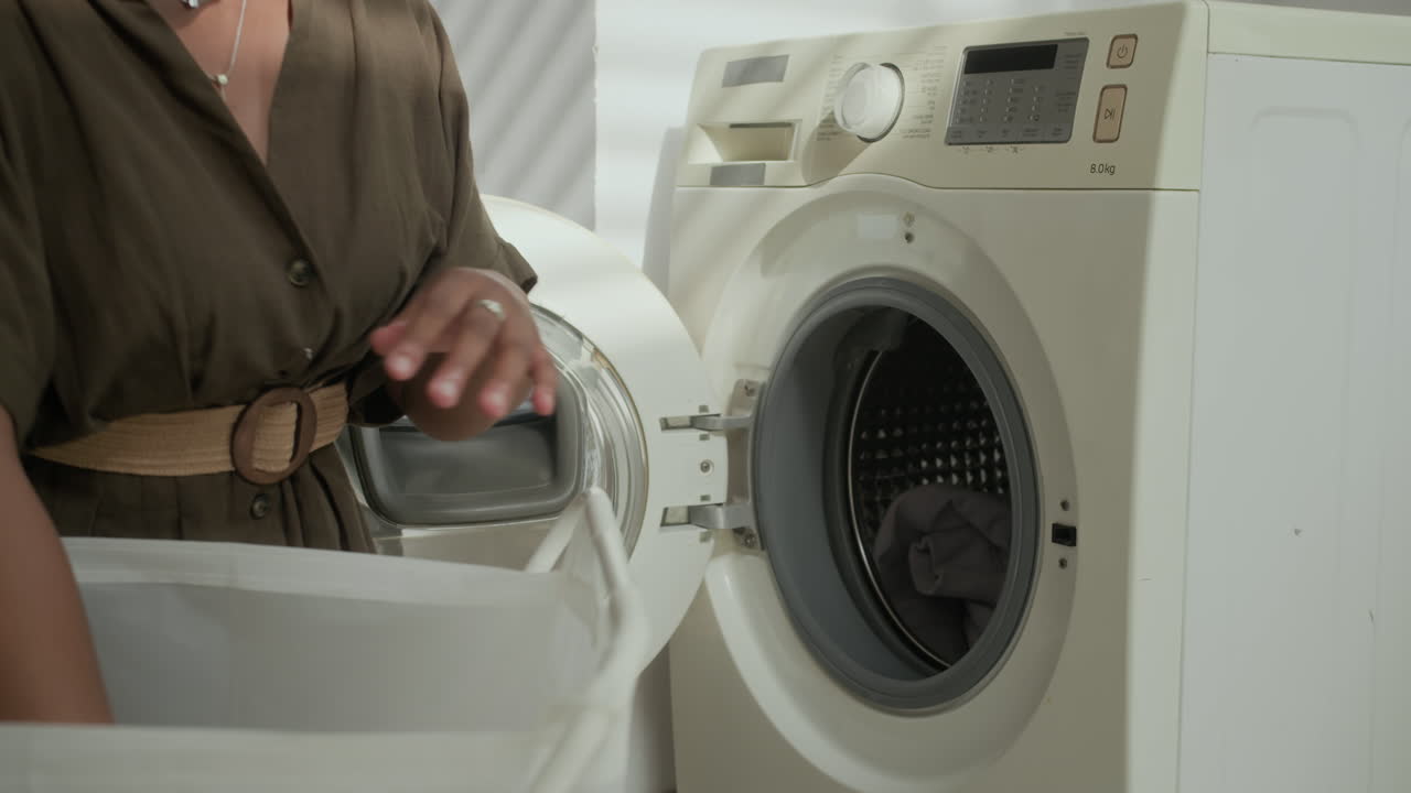 Housewife Filling Washing Machine with Laundry