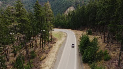 Vista-Aérea-De-Un-Camión-Negro-Conduciendo-Por-Una-Carretera-En-Columbia-Británica,-Canadá