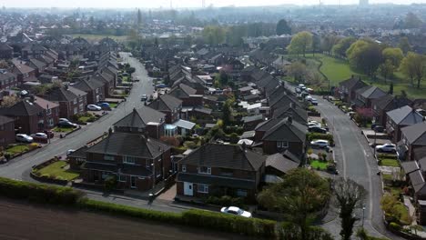 Countryside-housing-estate-aerial-view-flying-above-ploughed-England-farmland-residential-homes-dolly-left