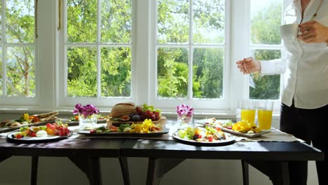 Friends-having-cup-of-coffee-with-various-delicious-foods-on-table