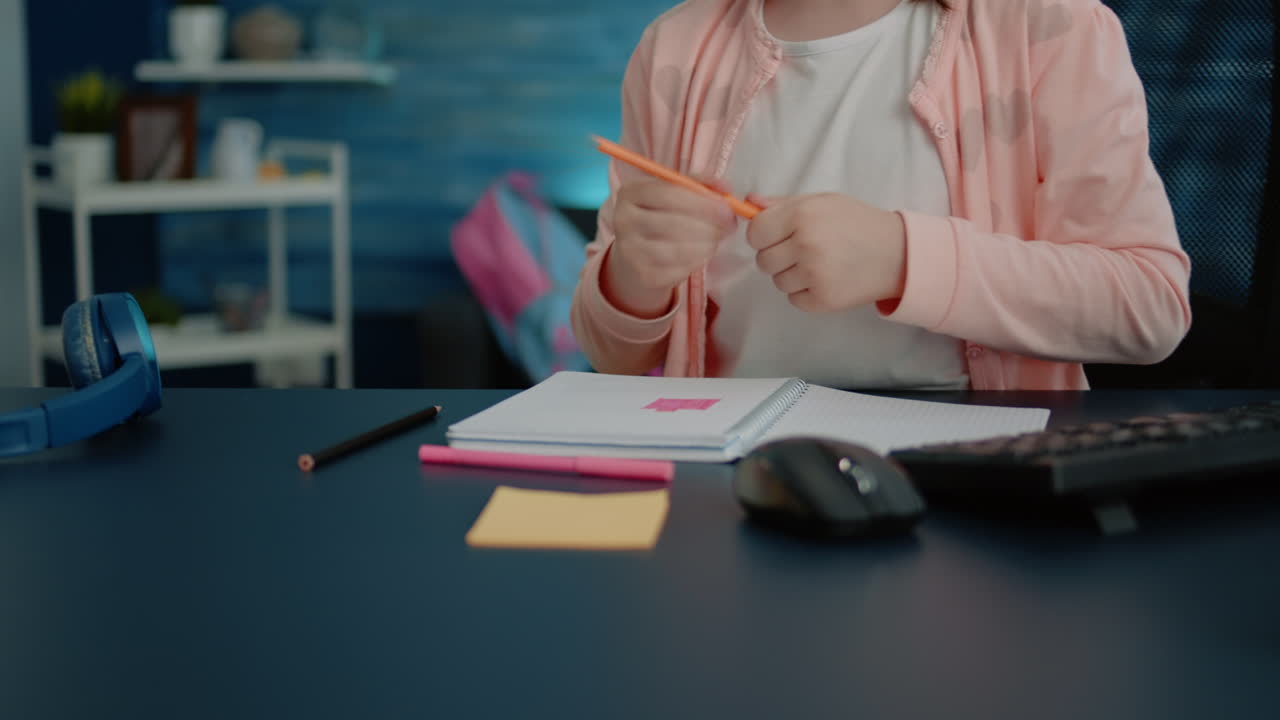 Close up of hands of child using pencils for colorful notebook